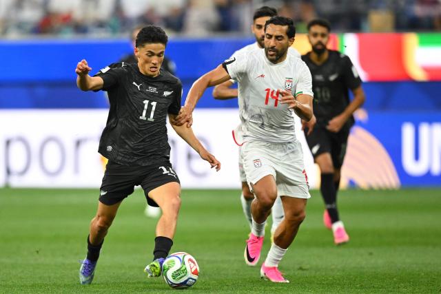 New Zealand's forward #11 Elijah Just and Iran's midfielder #14 Saman Ghoddos fight for the ball during the 2026 World Cup Group G football match between Iran and New Zealand at Los Angeles Stadium in Inglewood on June 15, 2026.  (Photo by Patrick T. Fallon / AFP)