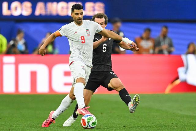 Iran's forward #09 Mehdi Taremi and New Zealand's midfielder #06 Joe Bell fight for the ball during the 2026 World Cup Group G football match between Iran and New Zealand at Los Angeles Stadium in Inglewood on June 15, 2026.  (Photo by Patrick T. Fallon / AFP)