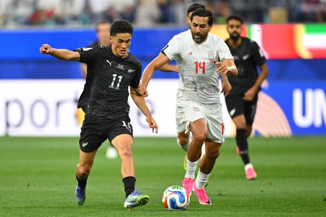 New Zealand's forward #11 Elijah Just and Iran's midfielder #14 Saman Ghoddos fight for the ball during the 2026 World Cup Group G football match between Iran and New Zealand at Los Angeles Stadium in Inglewood on June 15, 2026.  (Photo by Patrick T. Fallon / AFP)