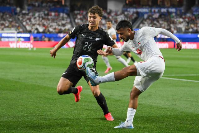 Iran's midfielder #10 Mehdi Ghayedi (R) kicks the ball past New Zealand's defender #24 Callan Elliot (L) during the 2026 World Cup Group G football match between Iran and New Zealand at Los Angeles Stadium in Inglewood on June 15, 2026.  (Photo by Patrick T. Fallon / AFP)