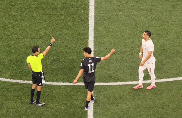 Mexican referee Cesar Arturo Ramos shows a yellow card to Iran's defender #03 Ehsan Hajsafi during the 2026 World Cup Group G football match between Iran and New Zealand at Los Angeles Stadium in Inglewood on June 15, 2026.  (Photo by Etienne Laurent / AFP)