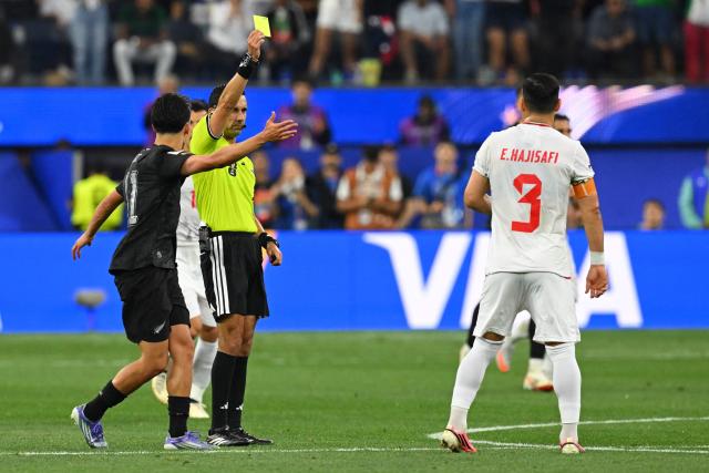 Mexican referee Cesar Arturo Ramos shows a yellow card to Iran's defender #03 Ehsan Hajsafi during the 2026 World Cup Group G football match between Iran and New Zealand at Los Angeles Stadium in Inglewood on June 15, 2026.  (Photo by Patrick T. Fallon / AFP)