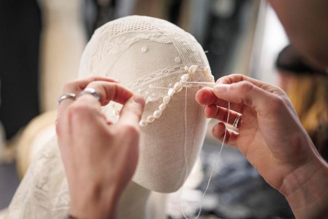 (FILES) A seamstress works on a upcycled fashion piece designed by Spanish designer, creative director and stylist, Maria Bernad, creator of "Les Fleurs studio" at her atelier in Paris on May 5, 2026. Lace is making a big comeback in fashion, bringing a touch of craftsmanship and delicacy, and this traditional fabric is now even being recycled to create unique pieces worn by stars such as Beyonce and Rosalia. (Photo by SIMON WOHLFAHRT / AFP)
