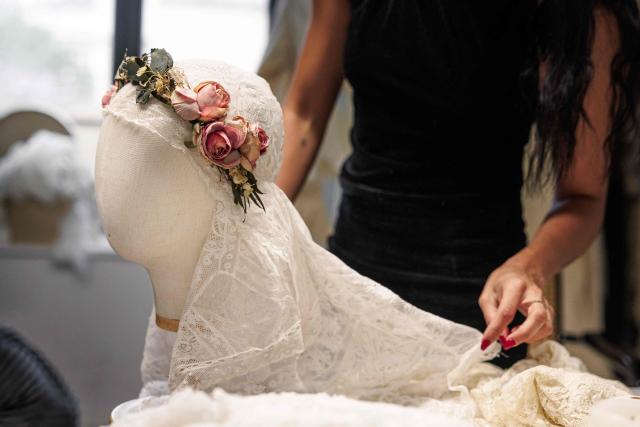 (FILES) Spanish designer, creative director and stylist, Maria Bernad, creator of "Les Fleurs studio" works on an upcycled fashion piece at her atelier in Paris on May 5, 2026. Lace is making a big comeback in fashion, bringing a touch of craftsmanship and delicacy, and this traditional fabric is now even being recycled to create unique pieces worn by stars such as Beyonce and Rosalia. (Photo by SIMON WOHLFAHRT / AFP)