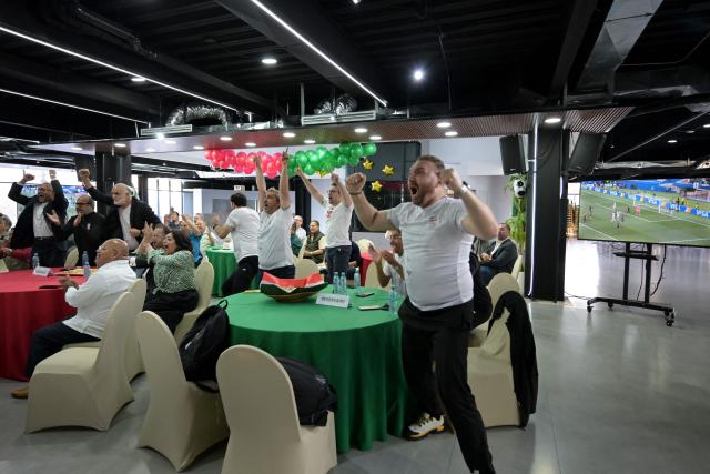 Iran's ambassador to Mexico Abolfazl Pasandideh, First Vice President of the Islamic Republic of Iran Football Federation Mehdi Mohammad Nabi and Iranian fans celebrate as they watch the 2026 World Cup Group G football match between Iran and New Zealand at the Chamber of Commerce in Tijuana, Mexico on June 15, 2026. (Photo by Guillermo Arias / AFP)