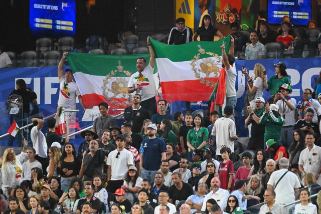 Iranian fans show pre-revolutionary Iranian flags cheering for their team during the 2026 World Cup Group G football match between Iran and New Zealand at Los Angeles Stadium in Inglewood on June 15, 2026.  (Photo by Patrick T. Fallon / AFP)