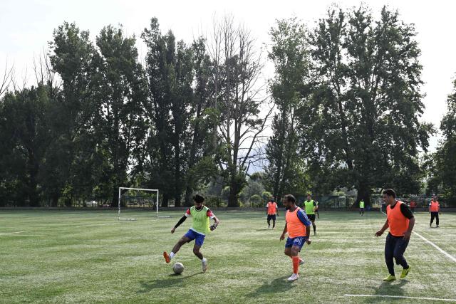 Kashmiri residents play football at a stadium in Srinagar on June 16, 2026. (Photo by Tauseef MUSTAFA / AFP)
