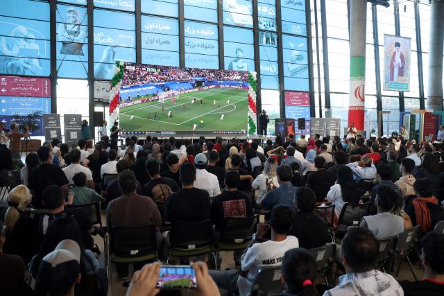 TOPSHOT - Iranians watch the 2026 World Cup football tournament match between Iran and New Zealand at Tehran Book Garden in Tehran, Iran, on June 16, 2026. (Photo by AFP)