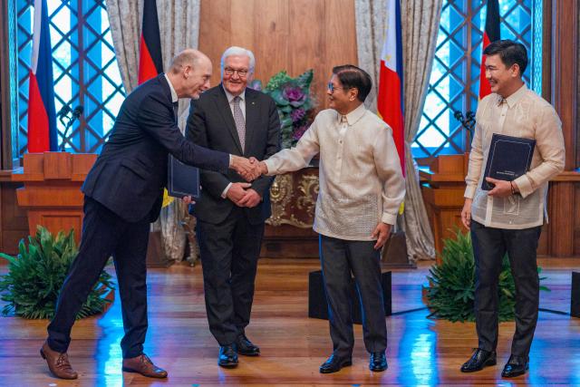 Lufthansa Technik Philippines President Holger Beck (L) shakes hands with Philippine President Ferdinand Marcos as German President Frank-Walter Steinmeier (2nd L) and Bases Conversion and Development Authority (BCDA) President Joshua Bingcang look on at the Malacanang Palace in Manila on June 16, 2026. (Photo by Ezra Acayan / POOL / AFP)