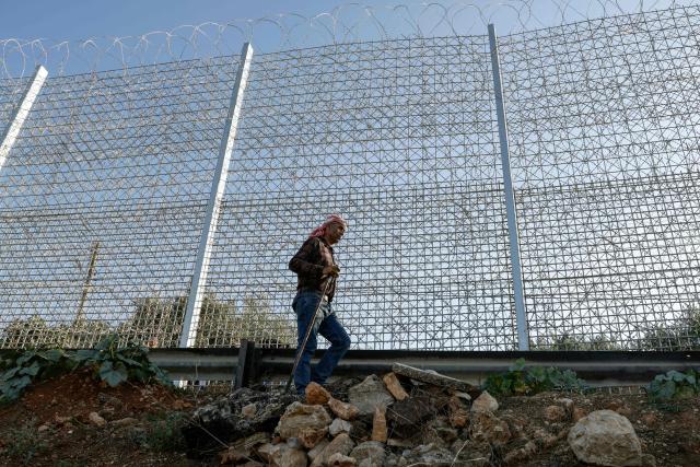 Palestinian farmer 40-year-old Mohammad Fuqaha works on the family’s farmland in the town of Sinjil, north of Ramallah in the occupied West Bank, which is surrounded by Israeli erected barbed wire and a metal fence, days after part of their crops were reportedly vandalized by Jewish settlers, according to the family on June 15, 2026. The occupied West Bank has been gripped by almost daily violence involving Israeli troops and settlers since the start of the Gaza war in October 2023. (Photo by Zain JAAFAR / AFP)