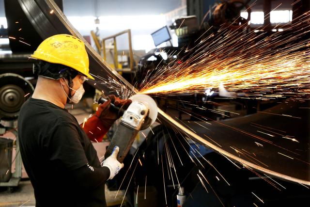 A worker uses a grinder on a part of a wind turbine in the workshop of the Zhongshan Wind Power Equipment Co. in Lianyungang, in China’s eastern Jiangsu province on June 16, 2026. (Photo by CN-STR / AFP) / China OUT