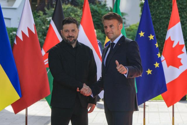France's President Emmanuel Macron greets Ukraine's President Volodymyr Zelensky ahead of the working session with G7 leaders and Ukraine during the G7 summit, in Evian, eastern France, on June 16, 2026. A G7 summit is set to take place June 15 to 17 in the French town of Evian-les-Bains near Switzerland and it will be attended by country leaders as well as the EU's foreign policy chief and ministers from Brazil, Canada, the United Arab Emirates and Turkey. (Photo by Ludovic MARIN / AFP)