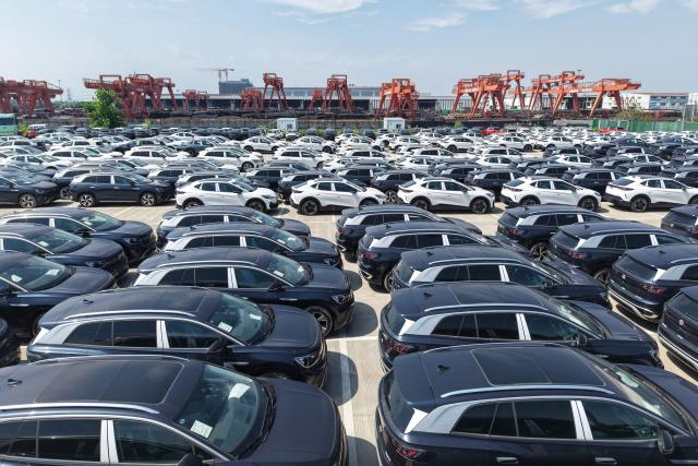 Chinese-manufactured Volkswagen cars are seen on a dock at the International Automobile Trade Port in the Hangzhou section of the Beijing-Hangzhou Grand Canal, in Hangzhou, in China’s eastern Zhejiang province, before being transported to another port from where they will be exported, on June 15, 2026. (Photo by CN-STR / AFP) / China OUT