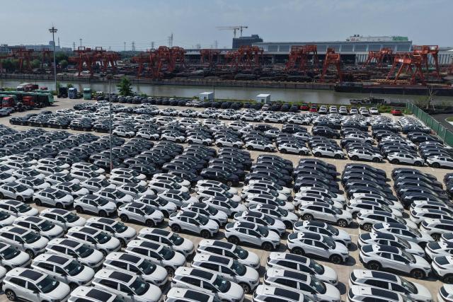 Chinese-manufactured Volkswagen cars are seen on a dock at the International Automobile Trade Port in the Hangzhou section of the Beijing-Hangzhou Grand Canal, in Hangzhou, in China’s eastern Zhejiang province, before being transported to another port from where they will be exported, on June 15, 2026. (Photo by CN-STR / AFP) / China OUT