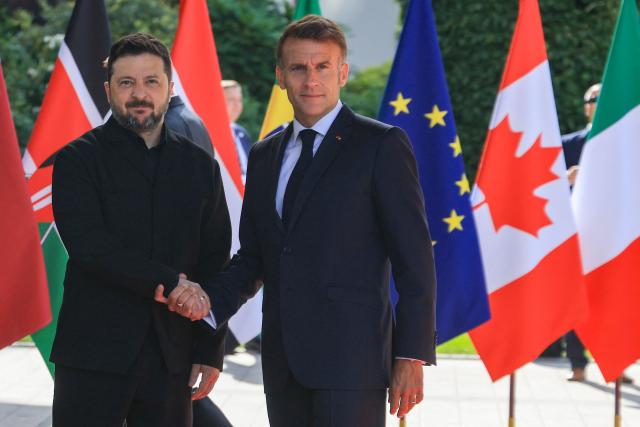 France's President Emmanuel Macron greets Ukraine's President Volodymyr Zelensky ahead of the working session with G7 leaders and Ukraine during the G7 summit, in Evian, eastern France, on June 16, 2026. A G7 summit is set to take place June 15 to 17 in the French town of Evian-les-Bains near Switzerland and it will be attended by country leaders as well as the EU's foreign policy chief and ministers from Brazil, Canada, the United Arab Emirates and Turkey. (Photo by Ludovic MARIN / AFP)