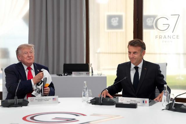 US President Donald Trump (L) and France's President Emmanuel Macron take part in a working session at the G7 summit in Evian-les-Bains, central-eastern France on June 16, 2026. (Photo by Thibault Camus / POOL / AFP)