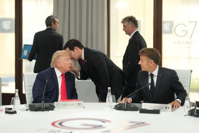 US Secretary of State Marco Rubio (C) speaks with US President Donald Trump (L) next to France's President Emmanuel Macron during a working session at the G7 summit in Evian-les-Bains, central-eastern France on June 16, 2026. (Photo by Thibault Camus / POOL / AFP)