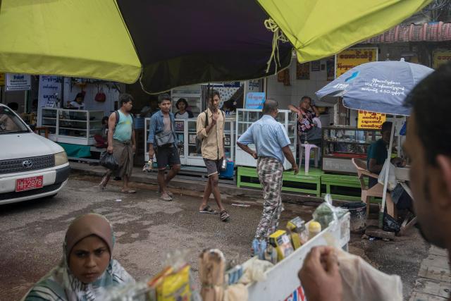 People walk along a street in Yangon on June 16, 2026. (Photo by Sai Aung MAIN / AFP)