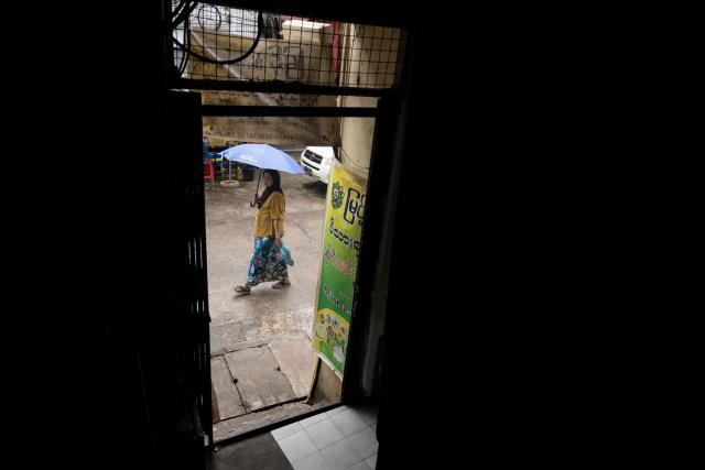 A woman walks along a street in Yangon on June 16, 2026. (Photo by Sai Aung MAIN / AFP)