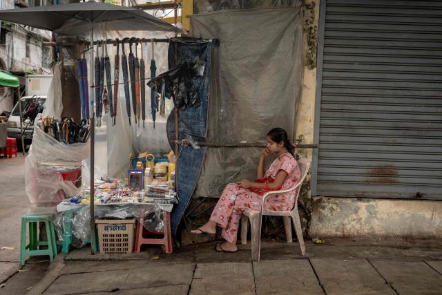 A woman sits at her street stall while waiting for customers in Yangon on June 16, 2026. (Photo by Sai Aung MAIN / AFP)