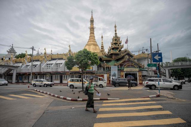 A man walks past Sule Pagoda in Yangon on June 16, 2026. (Photo by Sai Aung MAIN / AFP)