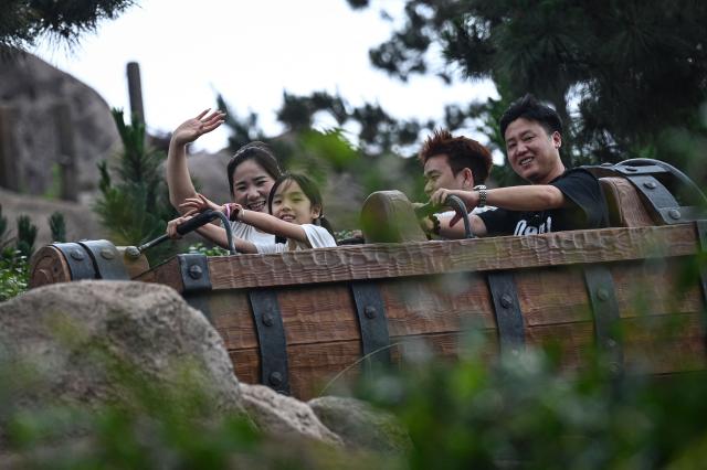 Visitors ride the 'Seven Dwarfs Mine Train' at Shanghai Disney Resort in Shanghai on June 16, 2026. (Photo by Jade Gao / AFP)