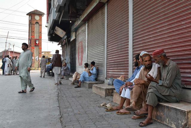 People gather near closed shops at a marketplace in Muzaffarabad, the capital of Pakistan-administered Kashmir on June 16, 2026 amid protests called by the Joint Awami Action Committee (JAAC) following the group’s ban under anti-terrorism laws by local authorities. The death toll from clashes between police and members of a banned protest movement in Pakistan-administered Kashmir has risen to 20, according to an AFP tally on June 12 based on official figures. (Photo by AFP)