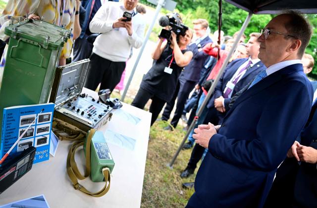 German Interior Minister Alexander Dobrindt looks at old Soviet spy equipment on display as he tours a series of exhibits during the inauguration of a Joint Center for Countering Hybrid Threats (GAZ Hybrid) in Berlin on June 16, 2026. The core mission of GAZ Hybrid is, according to the Interior Ministry, to identify and combat espionage, sabotage, disinformation, proliferation, transnational repression, state terrorism, and other forms of hybrid threats. (Photo by John MACDOUGALL / AFP)
