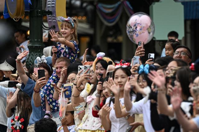 Visitors watch a parade at Shanghai Disney Resort in Shanghai on June 16, 2026. (Photo by Jade Gao / AFP)