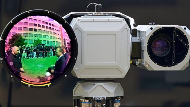 German Interior Minister Alexander Dobrindt (C-L) is reflected in a Aartos video camera for detecting to drones during a tour of exhibits following the inauguration of the Joint Center for Countering Hybrid Threats (GAZ Hybrid) in Berlin on June 16, 2026. The core mission of GAZ Hybrid is, according to the Interior Ministry, to identify and combat espionage, sabotage, disinformation, proliferation, transnational repression, state terrorism, and other forms of hybrid threats. (Photo by John MACDOUGALL / AFP)