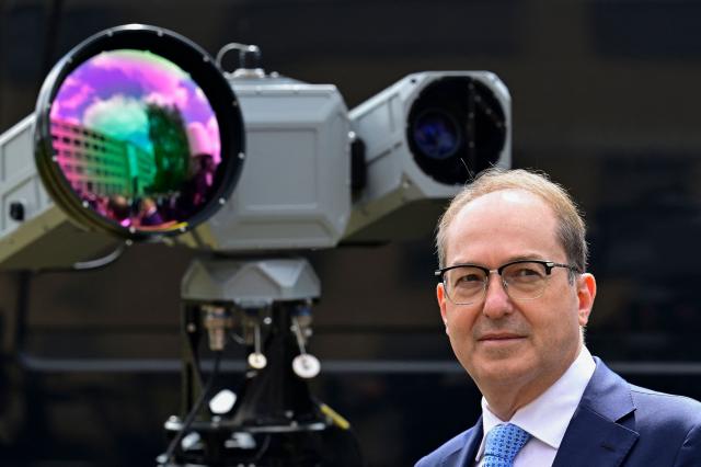 German Interior Minister Alexander Dobrindt poses next to an Aartos video camera to detect drones during a tour of exhibits following the inauguration of the Joint Center for Countering Hybrid Threats (GAZ Hybrid) in Berlin on June 16, 2026. The core mission of GAZ Hybrid is, according to the Interior Ministry, to identify and combat espionage, sabotage, disinformation, proliferation, transnational repression, state terrorism, and other forms of hybrid threats. (Photo by John MACDOUGALL / AFP)