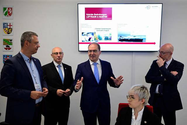German Interior Minister Alexander Dobrindt (C) speaks next to Sinan Selen, President of the Federal Office for the Protection of the Constitution (2ndL, Bundesamt fuer Verfassungsschutz), during a tour of the control room of the newly inaugurated Joint Center for Countering Hybrid Threats (GAZ Hybrid), in Berlin on June 16, 2026. The core mission of GAZ Hybrid is, according to the Interior Ministry, to identify and combat espionage, sabotage, disinformation, proliferation, transnational repression, state terrorism, and other forms of hybrid threats. (Photo by John MACDOUGALL / POOL / AFP)