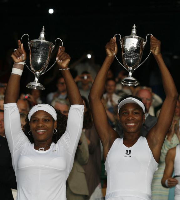 (FILES) US Serena Williams (L) and US Venus Williams hold up the trophy after winning against Australia's Samantha Stosur and Australia's Rennae Stubbs in their women's doubles final match on Day 12 at the 2009 Wimbledon tennis championships at the All England Club on July 4, 2009. Serena Williams will play at Wimbledon for the first time since 2022 after the US legend was given a wildcard to play the doubles event with her sister Venus on June 16, 2026. (Photo by GLYN KIRK / AFP)