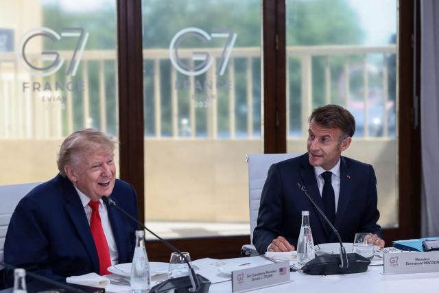 US President Donald Trump and French President Emmanuel Macron attend a work lunch as part of the G7 summit, in Evian, eastern France, on June 16, 2026. A G7 summit is set to take place June 15 to 17 in the French town of Evian-les-Bains near Switzerland and it will be attended by country leaders as well as the EU's foreign policy chief and ministers from Brazil, Canada, the United Arab Emirates and Turkey. (Photo by Evelyn Hockstein / POOL / AFP)
