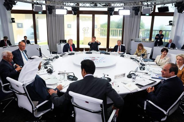 (From L) European Council President Antonio Costa, Germany's Chancellor Friedrich Merz, UAE's President Sheikh Mohamed bin Zayed al-Nahyan, US President Donald Trump, Qatar's Emir Sheikh Tamim bin Hamad al-Thani, France's President Emmanuel Macron, Canada's Prime Minister Mark Carney, Italy's Prime Minister Giorgia Meloni, Egypt's President Abdel Fattah al-Sisi, Japan's Prime Minister Sanae Takaichi and European Commission President Ursula von der Leyen attend a work lunch as part of the G7 summit, in Evian, eastern France, on June 16, 2026. A G7 summit is set to take place June 15 to 17 in the French town of Evian-les-Bains near Switzerland and it will be attended by country leaders as well as the EU's foreign policy chief and ministers from Brazil, Canada, the United Arab Emirates and Turkey. (Photo by Christian Hartmann / POOL / AFP)