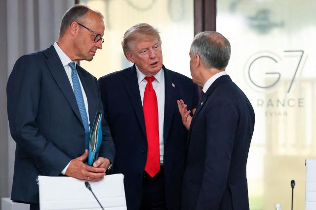 US President Donald Trump (C) speaks with Germany's Chancellor Friedrich Merz (L) and Canada's Prime Minister Mark Carney during a work lunch as part of the G7 summit, in Evian, eastern France, on June 16, 2026. A G7 summit is set to take place June 15 to 17 in the French town of Evian-les-Bains near Switzerland and it will be attended by country leaders as well as the EU's foreign policy chief and ministers from Brazil, Canada, the United Arab Emirates and Turkey. (Photo by Christian Hartmann / POOL / AFP)