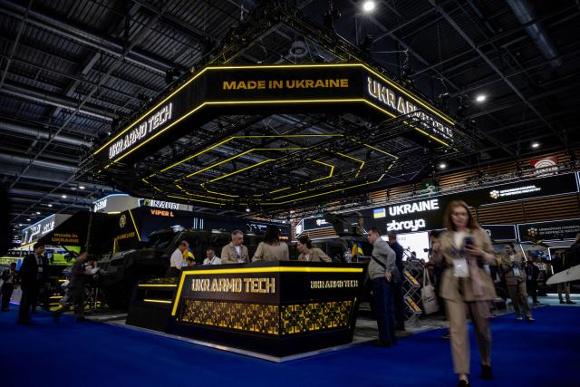 Visitor stand and walk at the stand of the Ukrainian company UkrAmoTech during the Eurosatory land and airland defence and security trade fair, at the Paris-Nord Villepinte Exhibition Centre in Villepinte, north of Paris on June 15, 2026. (Photo by Guillaume BAPTISTE / AFP)