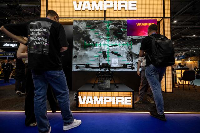Visitors watch screen displaying footage of a Vampire drone, at the stand of Ukraine based military technology startup specializing in unmanned aerial systems Skyfall, displayed during the Eurosatory land and airland defence and security trade fair, at the Paris-Nord Villepinte Exhibition Centre in Villepinte, north of Paris on June 15, 2026. (Photo by Guillaume BAPTISTE / AFP)