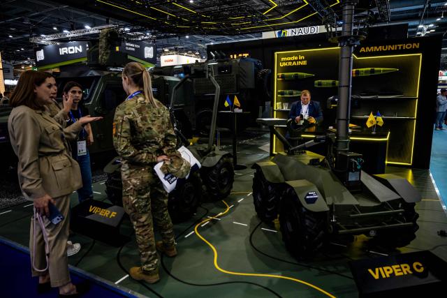 Attendees stand by Viper F and Viper C unmaned vehicles at the stand of Ukrainian company UkrArmoTech during the Eurosatory land and airland defence and security trade fair, at the Paris-Nord Villepinte Exhibition Centre in Villepinte, north of Paris on June 15, 2026. (Photo by Guillaume BAPTISTE / AFP)