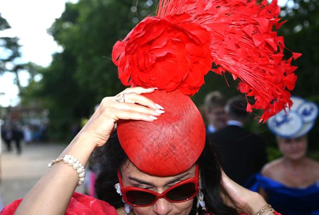 A racegoer poses for a photograph as they arrive on the first day of the Royal Ascot horse racing meeting in Ascot, west of London, on June 16, 2026. (Photo by JUSTIN TALLIS / AFP)