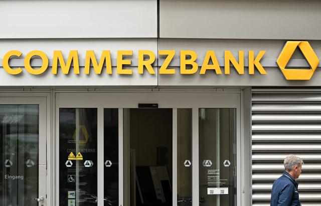 A pedestrian walks past a branch of Commerzbank in the banking district in Frankfurt am Main, western Germany, on June 16, 2026. Tuesday, June 16, marks the final day for UniCredit's hostile and highly political takeover offer for Commerzbank, as Italy's second-largest bank has its sights on an ambitious pan-European banking merger. (Photo by Kirill KUDRYAVTSEV / AFP)