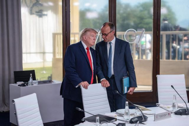 Germany’s Chancellor Friedrich Merz (R) and US President Donald Trump (L) attend a work lunch as part of the G7 summit, in Evian, eastern France, on June 16, 2026. A G7 summit is set to take place June 15 to 17 in the French town of Evian-les-Bains near Switzerland and it will be attended by country leaders as well as the EU's foreign policy chief and ministers from Brazil, Canada, the United Arab Emirates and Turkey. (Photo by Evelyn Hockstein / POOL / AFP)