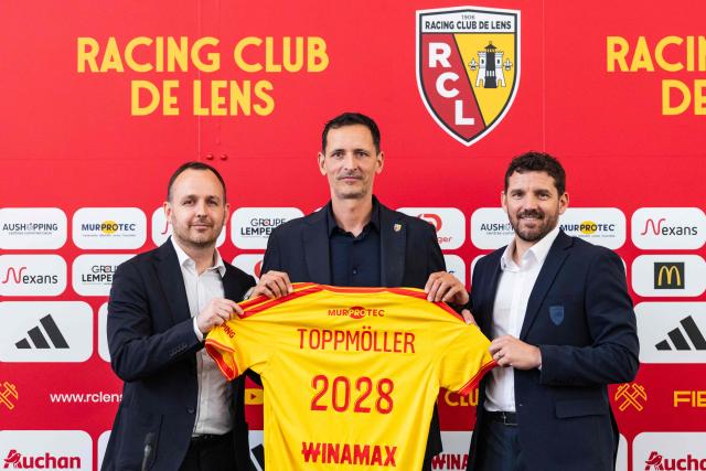 Lens' newly appointed football head coach Dino Toppmoller (C) poses with a jersey following a press conference with the club's general manager Benjamin Parrot (L) and the club's sporting director Jean-Louis Leca at the La Gaillette training centre in Avion, near Lens, northern France, on June 16, 2026. Lens announced the arrival of German coach Dino Toppmoller on a two-year deal. (Photo by Sameer Al-DOUMY / AFP)