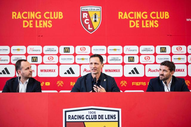 Lens' newly appointed football head coach Dino Toppmoller (C) delivers a speech during a press conference with the club's general manager Benjamin Parrot (L) and the club's sporting director Jean-Louis Leca at the La Gaillette training centre in Avion, near Lens, northern France, on June 16, 2026. Lens announced the arrival of German coach Dino Toppmoller on a two-year deal. (Photo by Sameer Al-DOUMY / AFP)