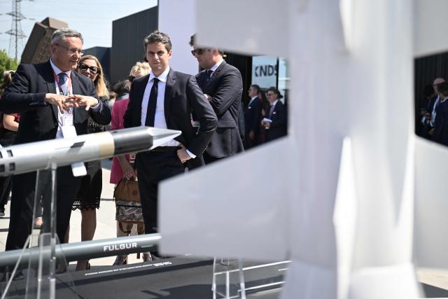 French centre-right party Renaissance's general secretary, former Prime Minister and  candidate for the 2027 French presidential election Gabriel Attal (C) visits MBDA's stand at Eurosatory, a land and airland defence and security trade fair, in Villepinte in the outskirts of Paris, on June 16, 2026. (Photo by JULIEN DE ROSA / AFP)