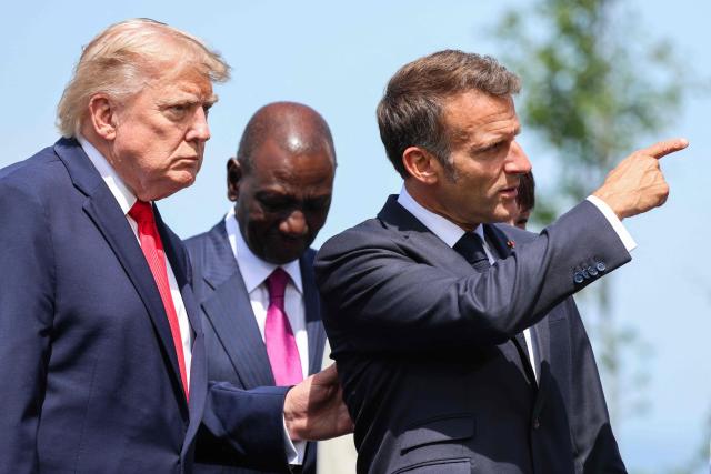 France's President Emmanuel Macron (R) gestures next to US President Donald Trump during a family photograph as part of the G7 summit, in Evian, eastern France, on June 16, 2026. A G7 summit is set to take place June 15 to 17 in the French town of Evian-les-Bains near Switzerland and it will be attended by country leaders as well as the EU's foreign policy chief and ministers from Brazil, Canada, the United Arab Emirates and Turkey. (Photo by Ludovic MARIN / POOL / AFP)
