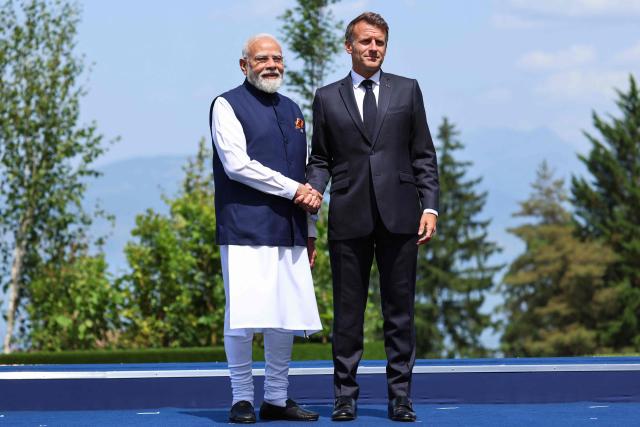 France's President Emmanuel Macron (R) welcomes India's Prime Minister Narendra Modi for the official greeting ahead of a work lunch as part of the G7 summit, in Evian, eastern France, on June 16, 2026. A G7 summit is set to take place June 15 to 17 in the French town of Evian-les-Bains near Switzerland and it will be attended by country leaders as well as the EU's foreign policy chief and ministers from Brazil, Canada, the United Arab Emirates and Turkey. (Photo by Ludovic MARIN / AFP)