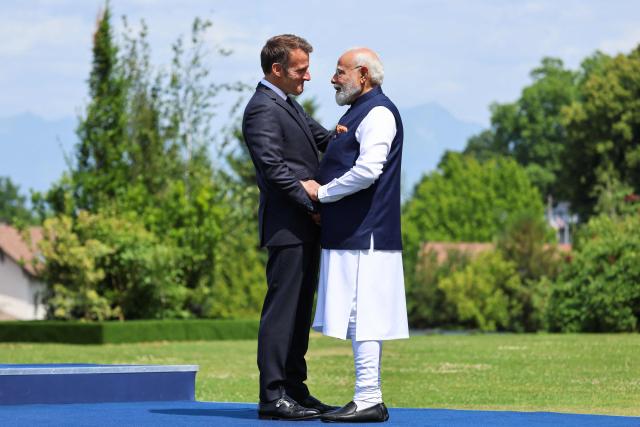 France's President Emmanuel Macron (L) welcomes India's Prime Minister Narendra Modi for the official greeting ahead of a work lunch as part of the G7 summit, in Evian, eastern France, on June 16, 2026. A G7 summit is set to take place June 15 to 17 in the French town of Evian-les-Bains near Switzerland and it will be attended by country leaders as well as the EU's foreign policy chief and ministers from Brazil, Canada, the United Arab Emirates and Turkey. (Photo by Ludovic MARIN / AFP)