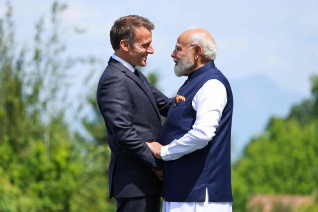 France's President Emmanuel Macron (L) welcomes India's Prime Minister Narendra Modi for the official greeting ahead of a work lunch as part of the G7 summit, in Evian, eastern France, on June 16, 2026. A G7 summit is set to take place June 15 to 17 in the French town of Evian-les-Bains near Switzerland and it will be attended by country leaders as well as the EU's foreign policy chief and ministers from Brazil, Canada, the United Arab Emirates and Turkey. (Photo by Ludovic MARIN / AFP)