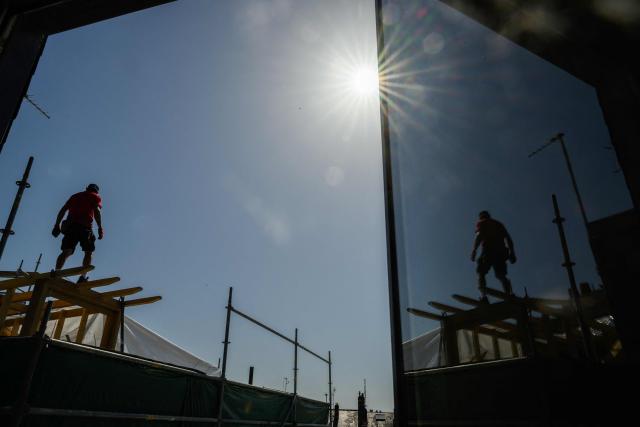 (FILES) A carpenter works on a rooftop during a hot sunny day in Nantes, western France, on May 27, 2026, as a heatwave hits France. The heatwave that is expected to hit France from June 17, 2026 could send temperatures soaring to "peaks of 40°C" on June 21, 2026, coinciding with the summer solstice, Météo-France has warned. (Photo by Loic VENANCE / AFP)